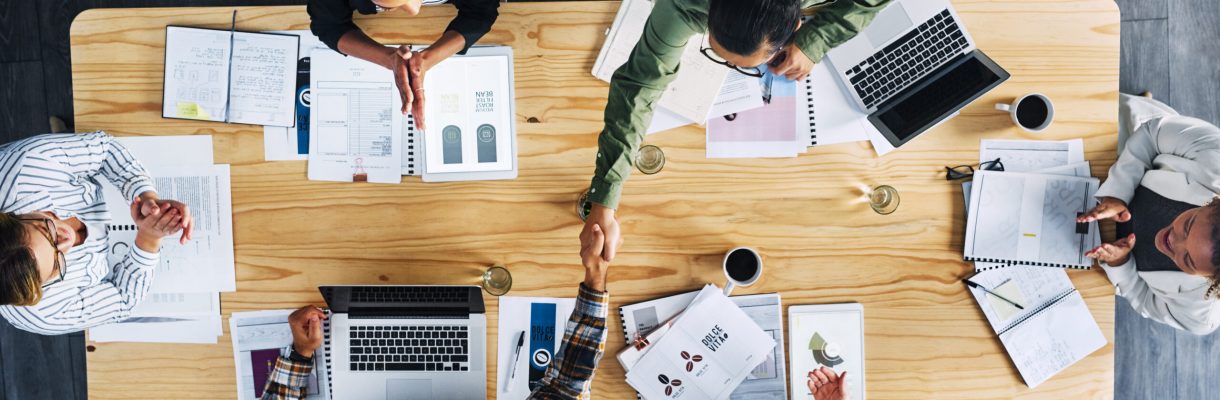 High angle shot of two businesspeople shaking hands during a meeting in an office